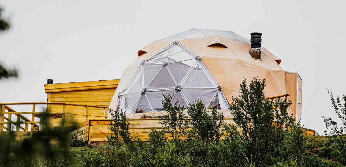 Una bonita casa domo con plataforma de madera situada entre árboles