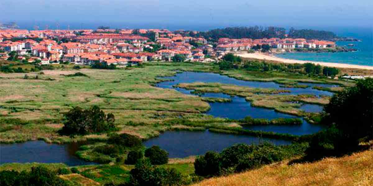 Preciosas vistas de la reserva natural de las marismas de Noja con las bonitas casas del pueblo por detrás