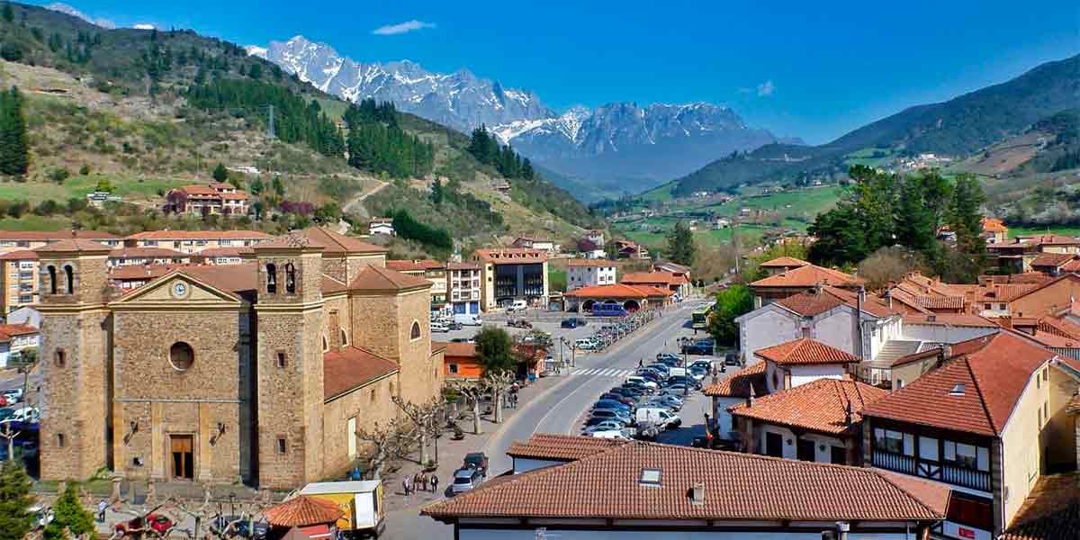 Preciosas vistas al hermoso pueblo de Cantabria Potes, donde se ve la iglesia, las casas tradicionales y las montañas nevadas al fondo