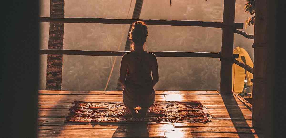 Mujer en una cabaña de madera meditando