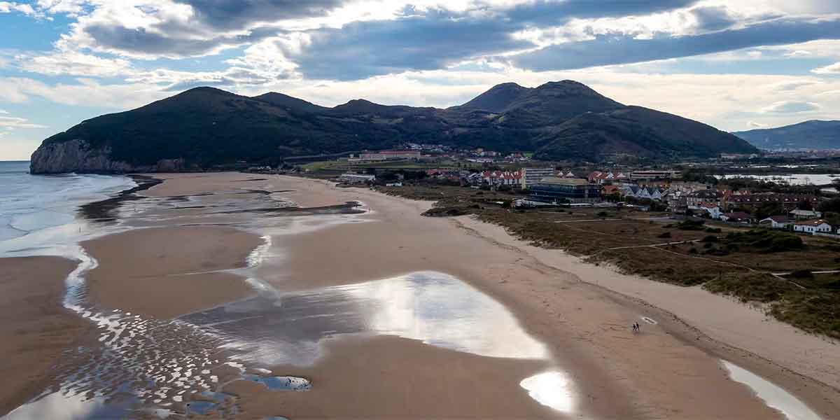 Increíbles vistas de Santoña con una inmensa playa de arena y las altas montañas detrás