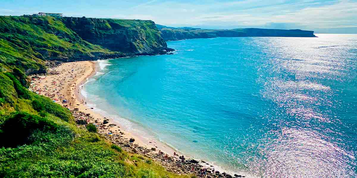 Una preciosa playa en Suances rodeada de impactantes acantilados llenos de vegetación verde y del bonito mar cántabro