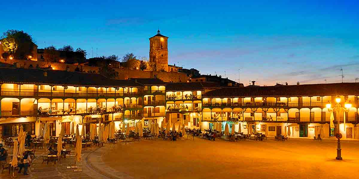 La preciosa plaza Mayor de uno de los pueblos bonitos cerca de Madrid, Chinchón, de noche con sus famosos arcos iluminados