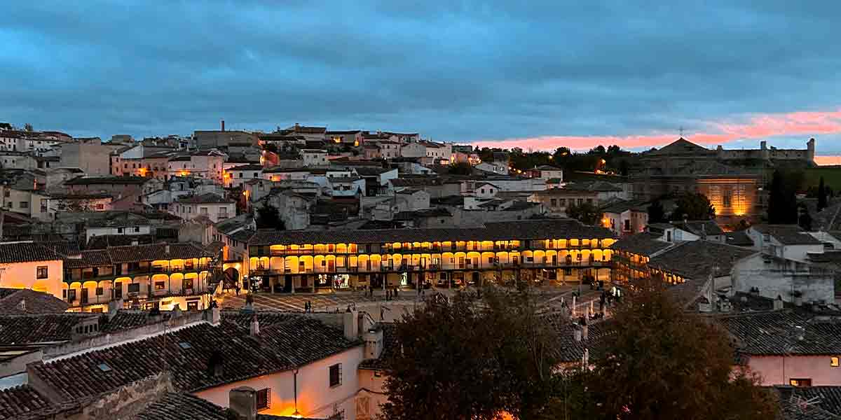 Vistas a la pintoresca Plaza Mayor de Chinchón, uno de los pueblos bonitos cerca de Madrid, con las bonitas luces cálidas encendidas durante el atardecer