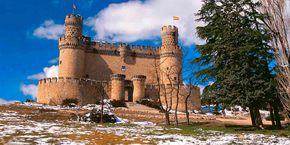 El inmenso Castillo de Manzanares El Real, incluido como uno de los pueblos bonitos cerca de Madrid, en perfecto estado y rodeado de nieve en un bonito día soleado 