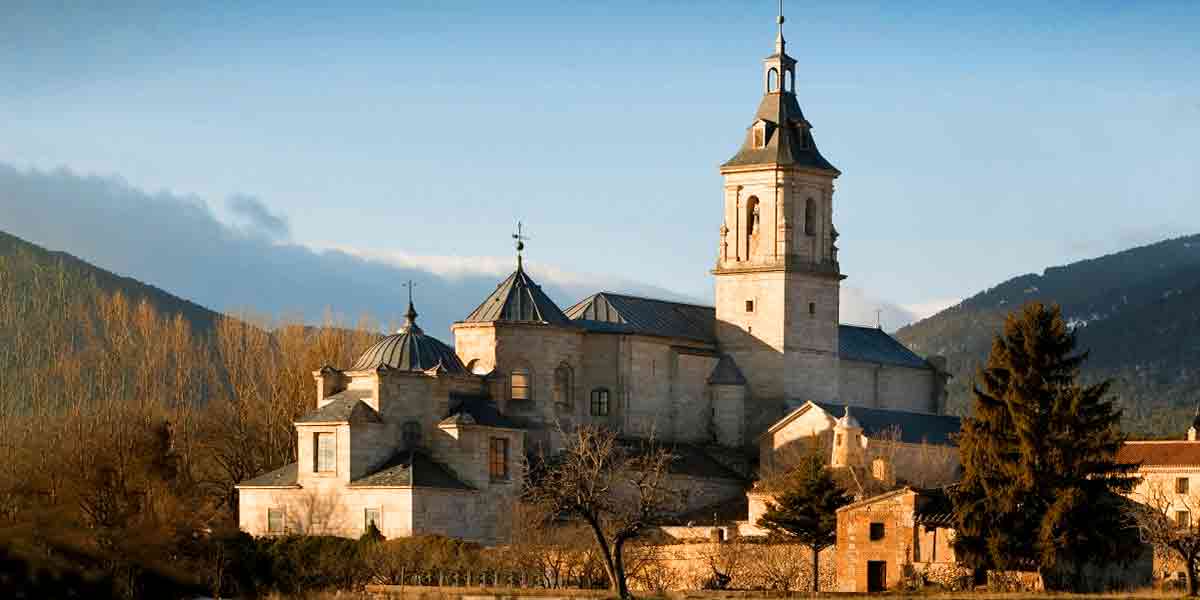 Vistas al imponente Monasterio de Santa María de El Paular en Rascafría rodeado de árboles y montañas, que de los pueblos bonitos cerca de Madrid es de los más llamativos