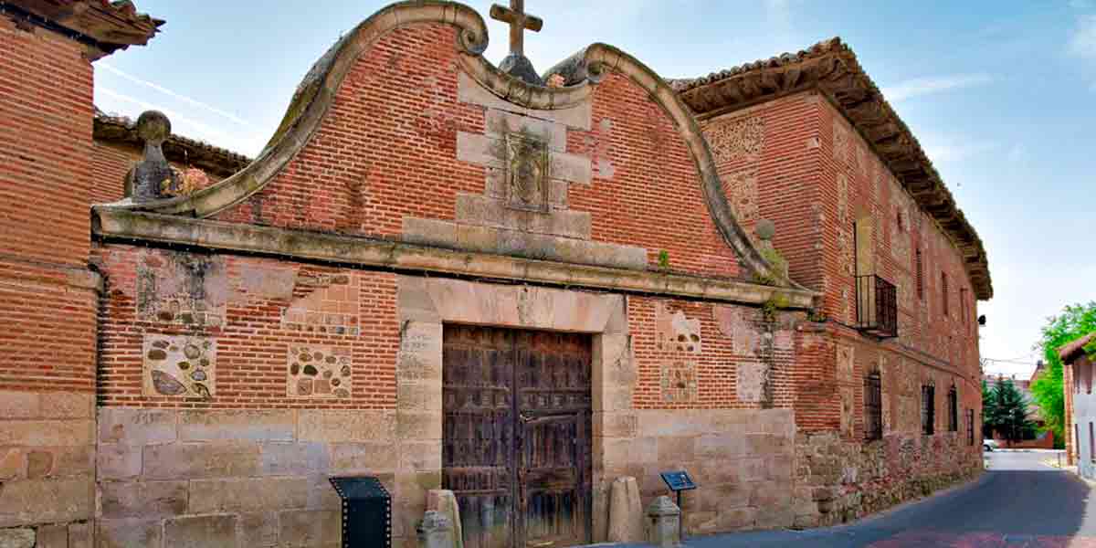 La grandiosa puerta principal de La Cartuja en Talamanca de Jarama con su cruz alta y sus antiguos ladrillos anaranjados