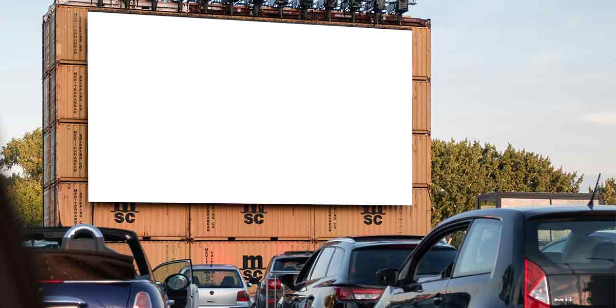 Un autocine repleto de parejas en coches, antes de que de comienzo la película