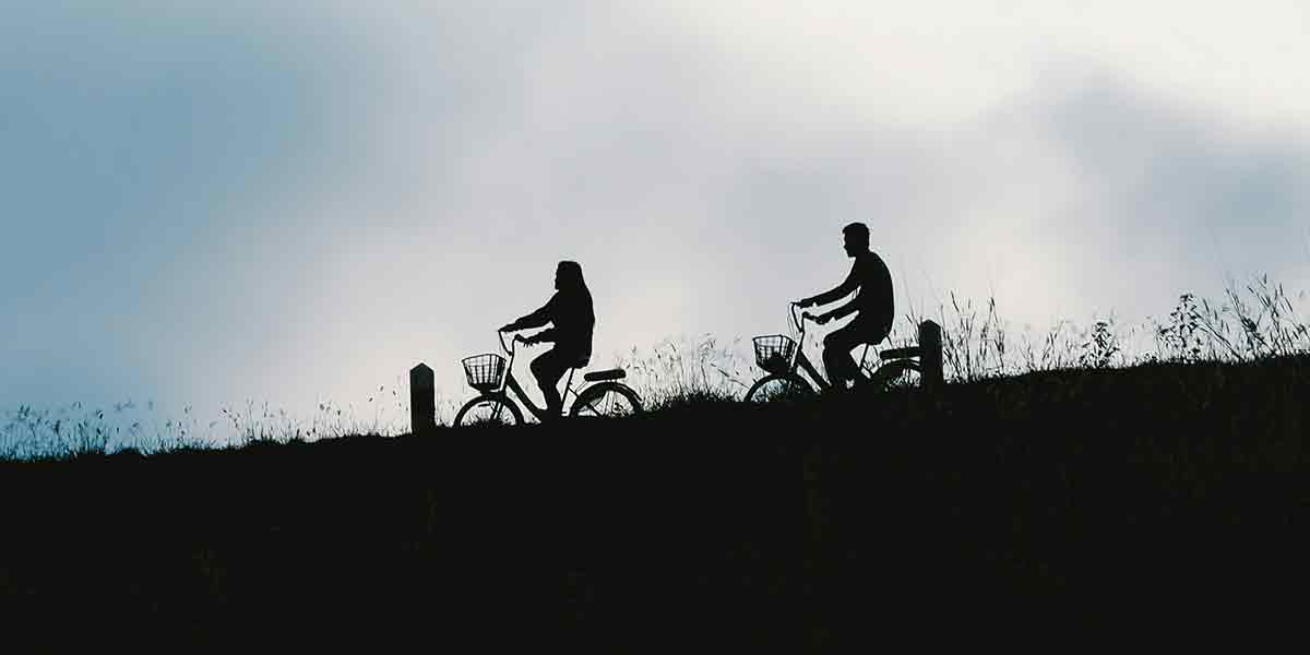 Una pareja disfrutando de un bonito momento de calidad paseando en bicicleta por el Parque Tierno Galván, uno de los planes en pareja Madrid más sanos y activos